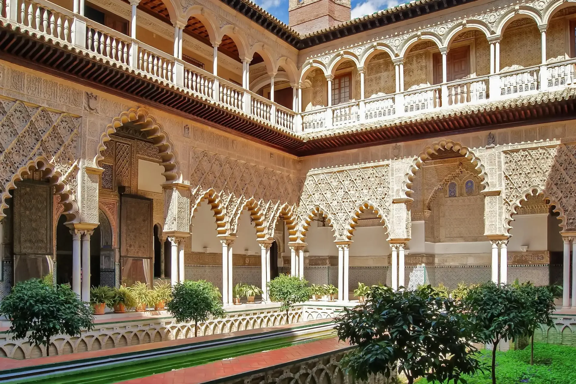 Patio de las Doncellas del Real Alcázar de Sevilla: columnas de mármol y estanque reflectante